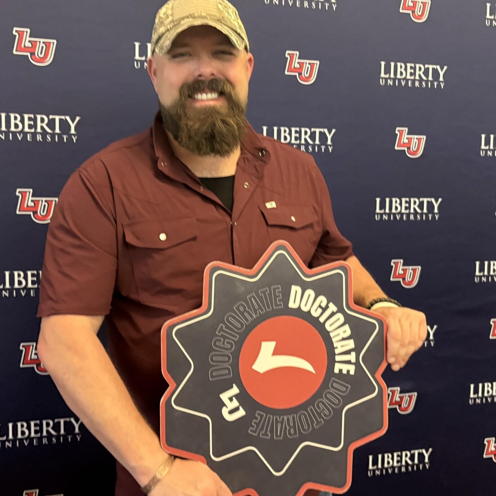 Dr. Patrick Stewart holding a Liberty University doctorate sign